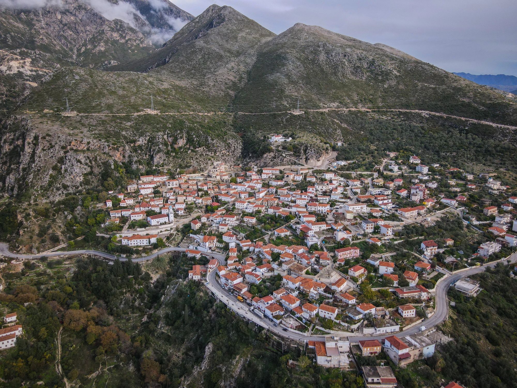 Traditional Albanian village surrounded by green mountains